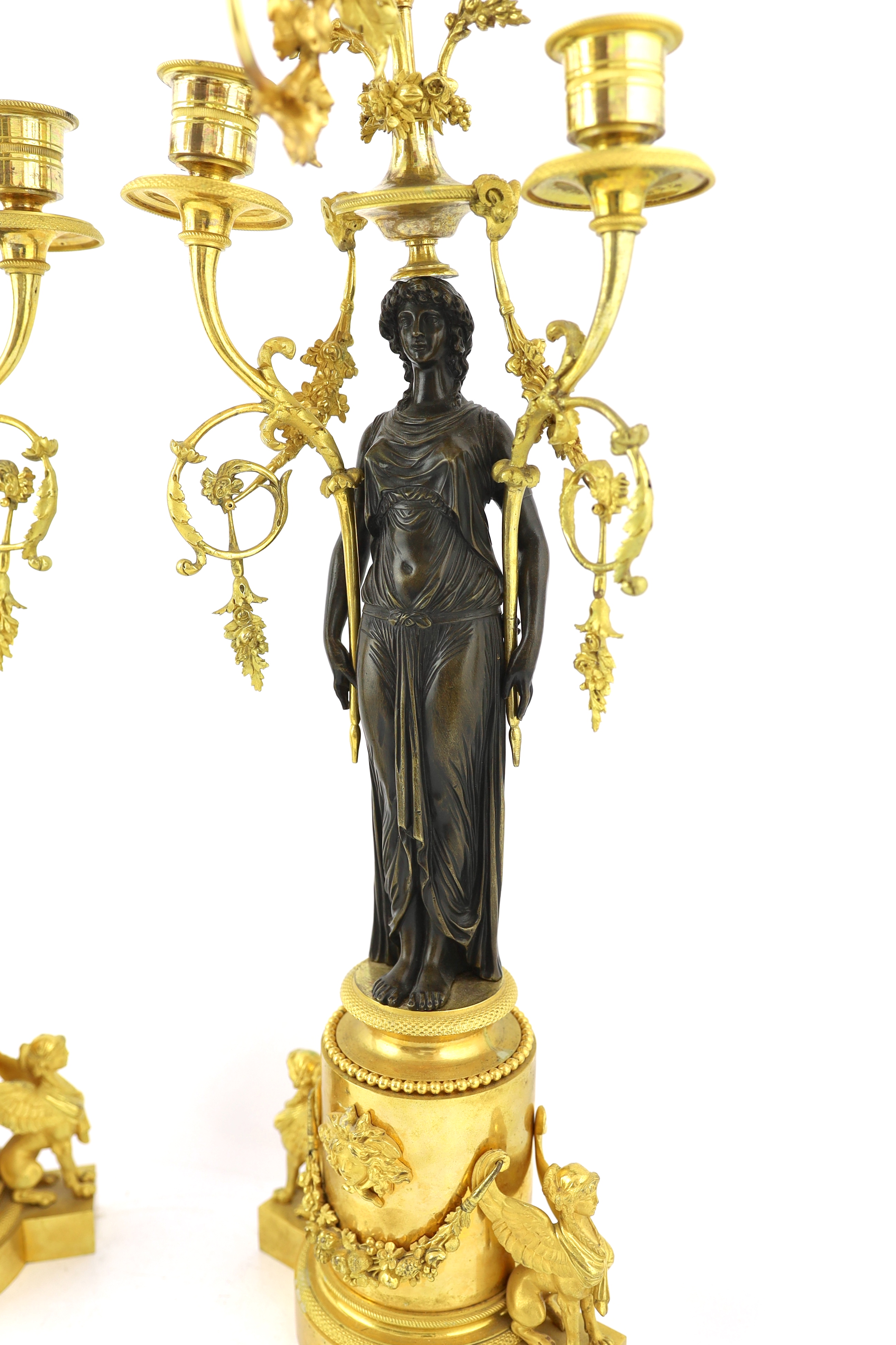 A pair of late 19th century French Empire style bronze and ormolu three light candelabra, 20cm wide, 63cm high, Please note this lot attracts an additional import tax of 5% on the hammer price